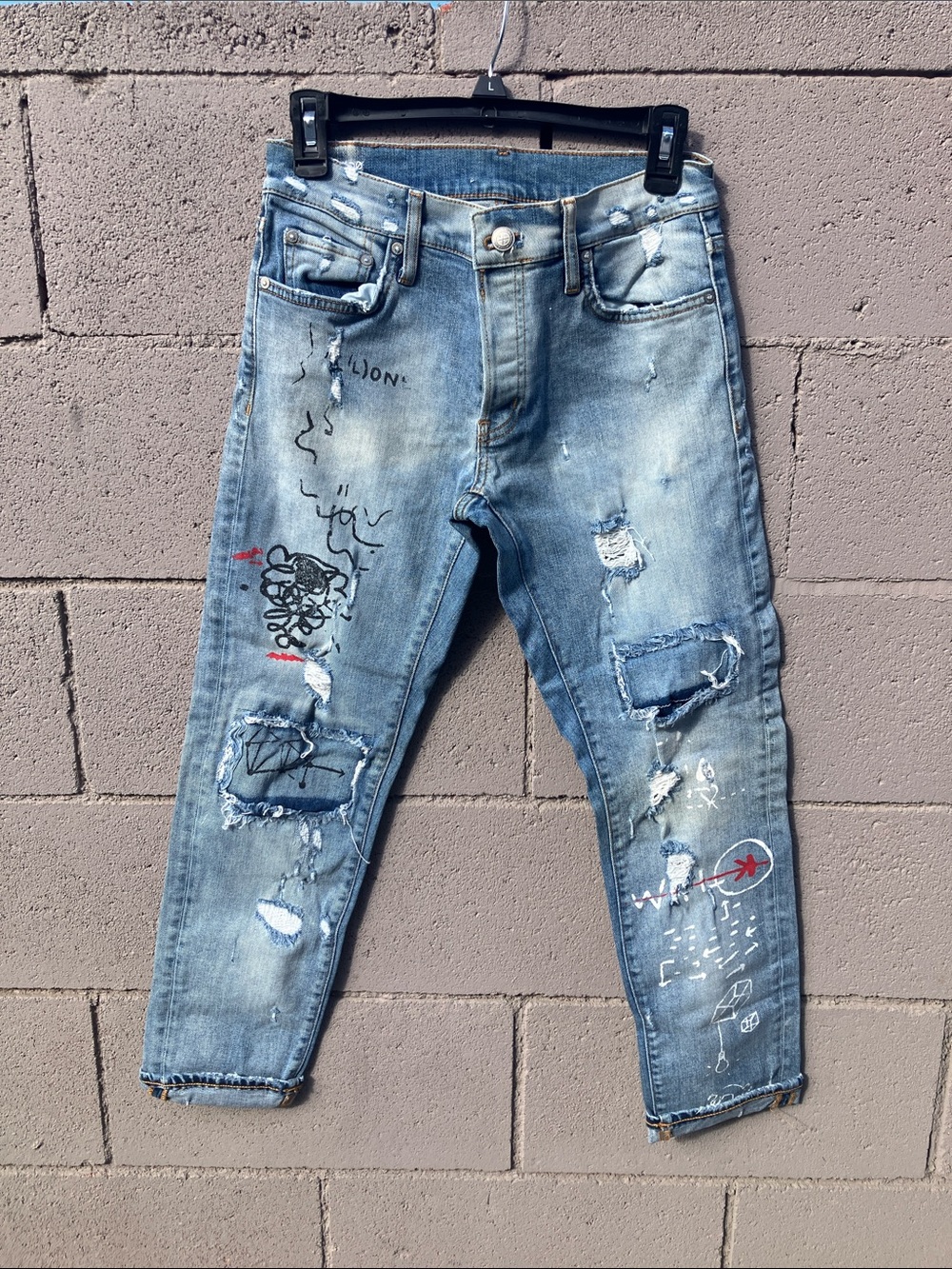 Distressed Light Blue Cropped Jeans with Paint-Style Accents